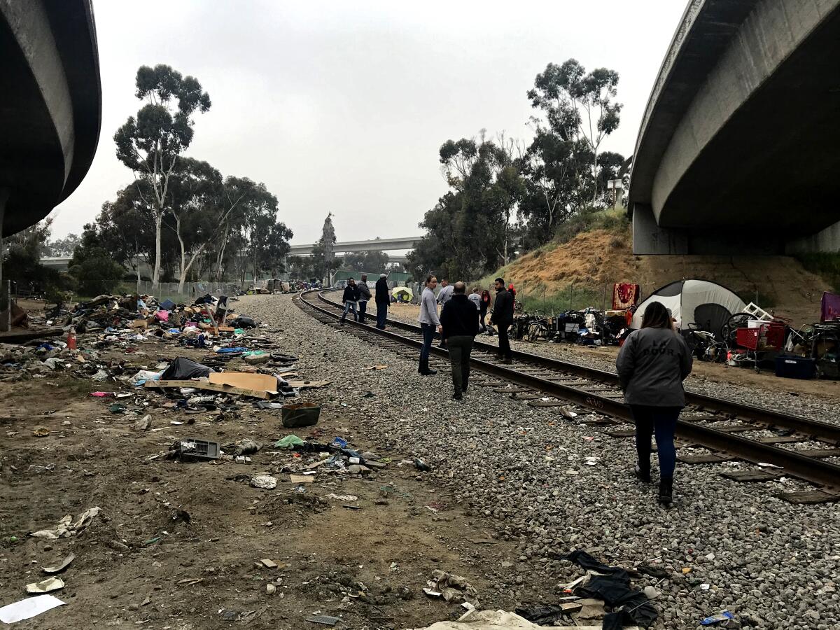 A team from Project 180 fan out to talk to homeless clients near the intersection of the 110 and 105 freeways in South Los Angeles.