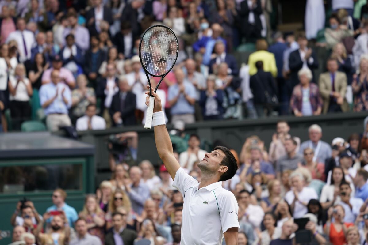 Serbia's Novak Djokovic celebrates after defeating Canada's Denis Shapovalov during the men's singles semifinals match on day eleven of the Wimbledon Tennis Championships in London, Friday, July 9, 2021. (AP Photo/Alberto Pezzali)