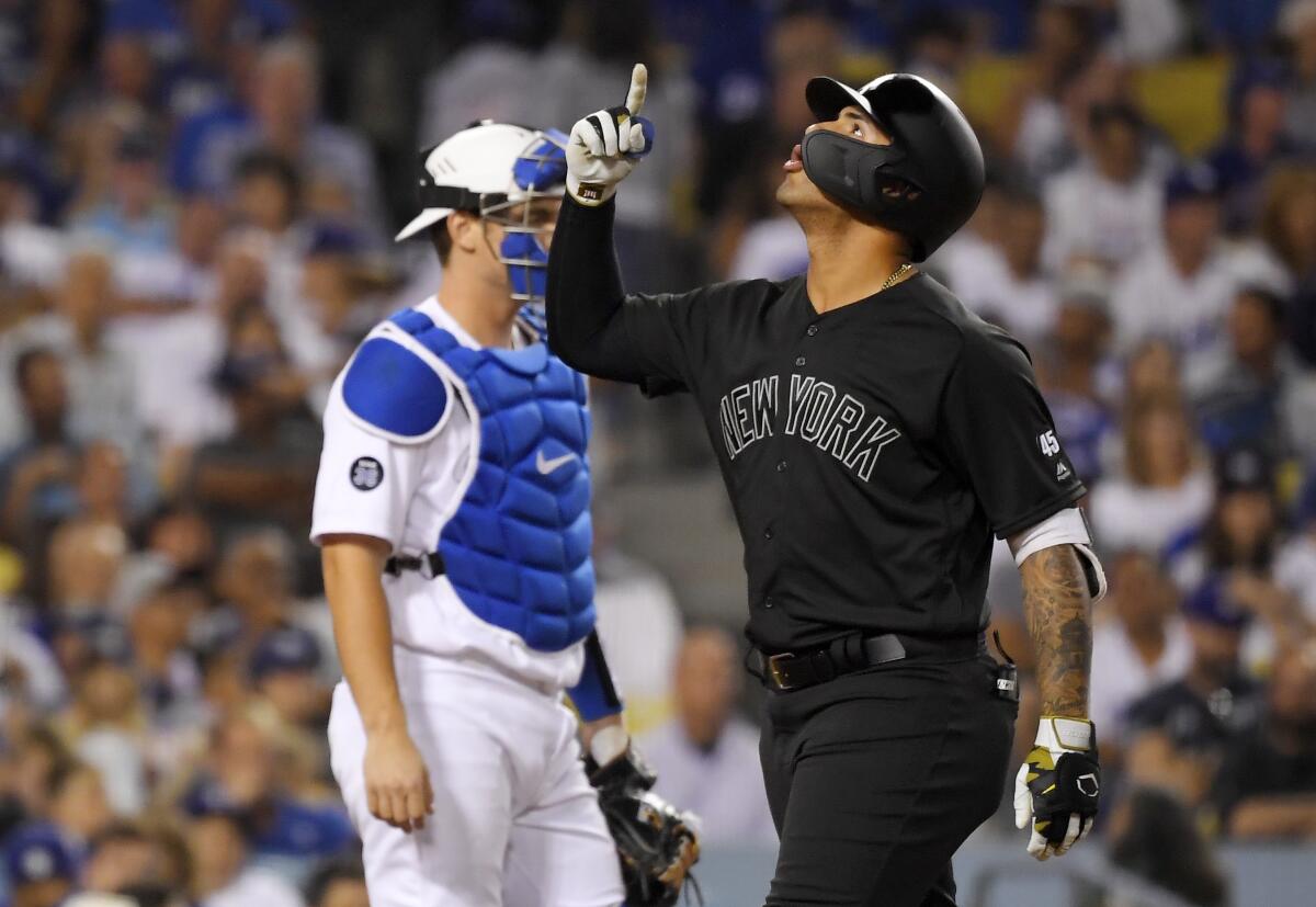 New York Yankees' Gleyber Torres, right, gestures as he scores on his solo home run, next to Los Angeles Dodgers catcher Will Smith during the sixth inning of a baseball game Friday, Aug. 23, 2019, in Los Angeles. (AP Photo/Mark J. Terrill)