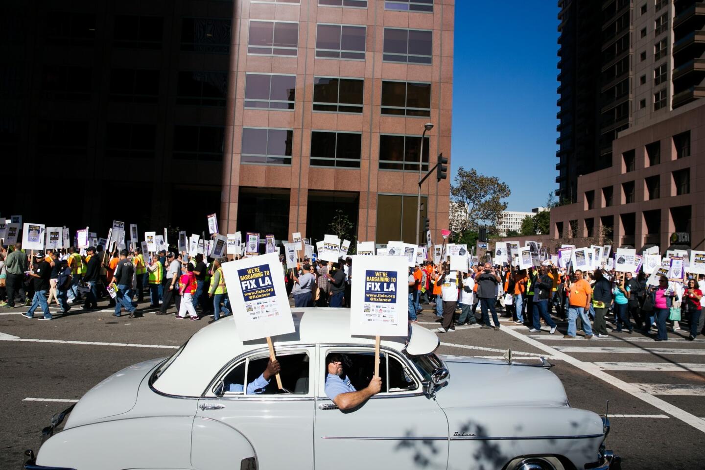 Jose Orozco drives his 1950's Chevy Bel Air with his friends to support members of the Coalition of L.A. City Unions as they march toward City Hall, under the banner, "We're Bargaining to Fix LA,."