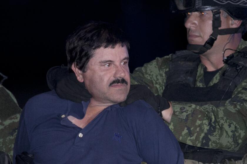 Joaquin "El Chapo" Guzman is made to face the press as he is escorted to a helicopter in handcuffs by Mexican soldiers and marines at a federal hangar in Mexico City on Jan. 8.