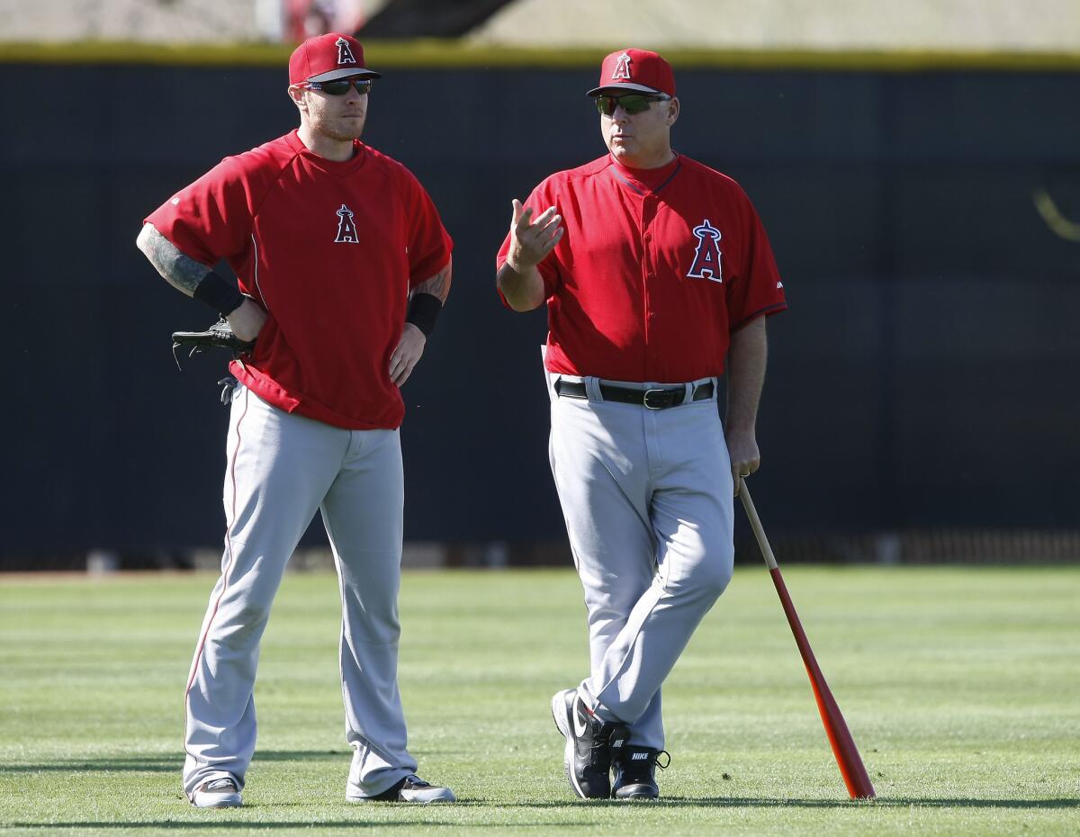 Angels Manager Mike Scioscia, right, talks with outfielder Josh Hamilton during a spring training practice on Feb. 20.
