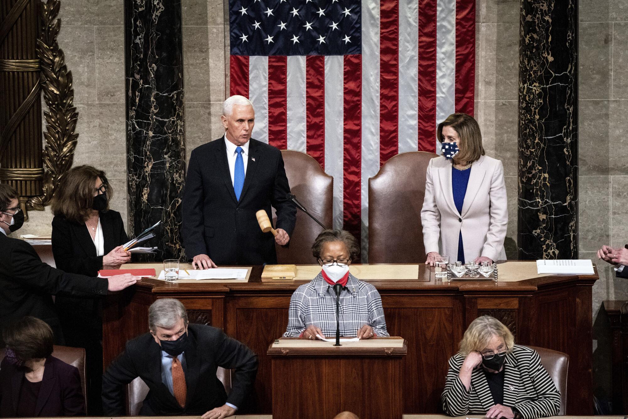 Mike Pence, left, and Nancy Pelosi, right, stand before the House chamber 