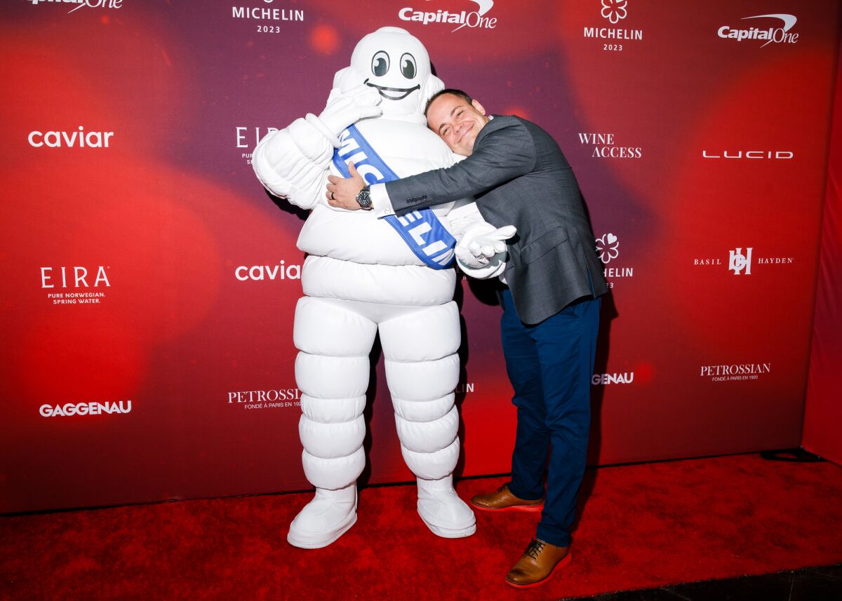 Robert Alcocer abraza a la mascota Michelin Man.
