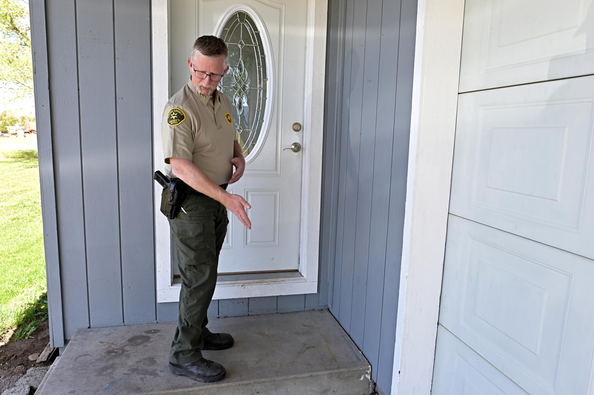 Sierra County Sheriff Mike Fisher stands on a stoop where wolves killed an elk.