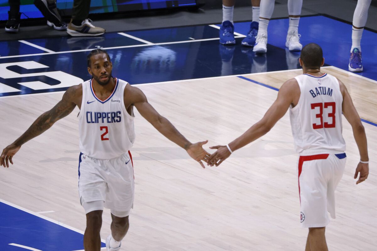 Los Angeles Clippers forward Nicolas Batum (33) congratulates forward Kawhi Leonard (2) after Leonard made a 3-point basket against the Dallas Mavericks in the second half during Game 6 of an NBA basketball first-round playoff series in Dallas, Friday, June 4, 2021. (AP Photo/Michael Ainsworth)