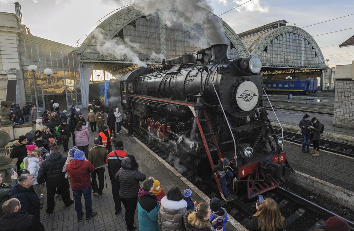 People wait to board a steam train.