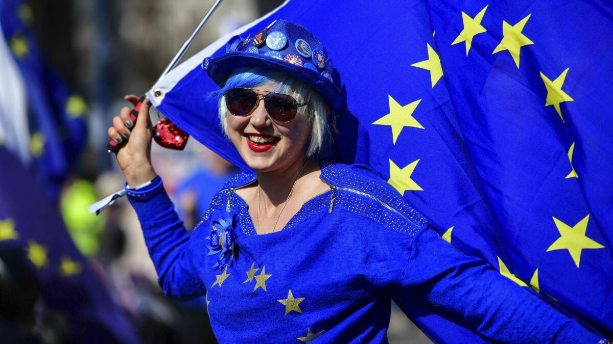 Madeleina Kay holds a European Union flag while singing about Brexit outside Parliament in London ahead of the latest round of debates in the lower house concerning Brexit issues on April 1, 2019.