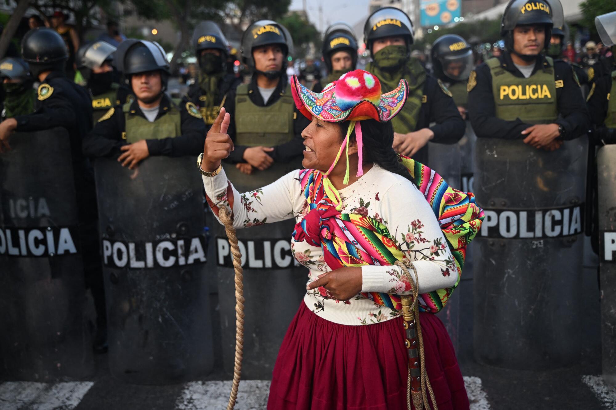 A protester gestures in front of police.