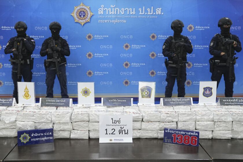Police officers stand behind seized crystal methamphetamine during a news conference in Bangkok, Thailand, Monday, May 29, 2023. Law enforcement officials in Thailand said Monday they seized more than a ton of crystal methamphetamine in a southern province last week that they believed was bound for Australia. (AP Photo/Thanachote Thanawikran)