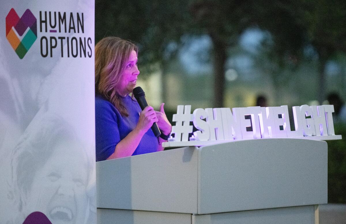 Human Options CEO Maricela Rios-Faust speaks at the Shine the Light walking vigil at Lions Park.