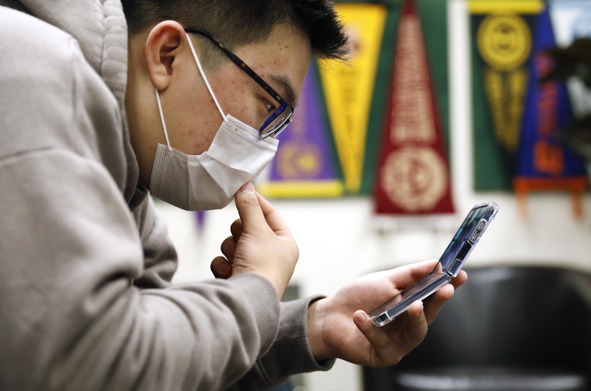 Kenji Horigome takes a video call during lunch at Downtown Magnets High School.