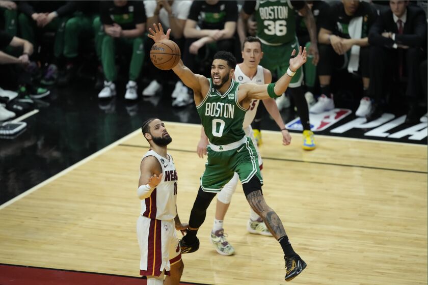 Boston Celtics forward Jayson Tatum (0) looses control of the ball after being fouled by Miami Heat forward Caleb Martin, left, during the second half of Game 6 of the NBA basketball Eastern Conference finals, Saturday, May 27, 2023, in Miami. (AP Photo/Rebecca Blackwell)