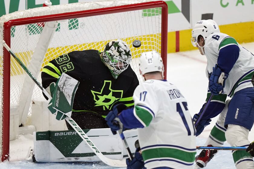 Dallas Stars goaltender Matt Murray (32) defends against Vancouver Canucks attackers Filip Hronek (17) and Brock Boeser (6) during the second period of an NHL hockey game in Dallas, Saturday, March 25, 2023. (AP Photo/LM Otero)