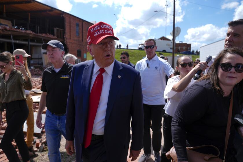 El candidato presidencial republicano, el expresidente Donald Trump, camina fuera de la tienda de muebles Chez What mientras visita Valdosta, Georgia, una ciudad afectada por el huracán Helene, el lunes 30 de septiembre de 2024. (AP Foto/Evan Vucci)