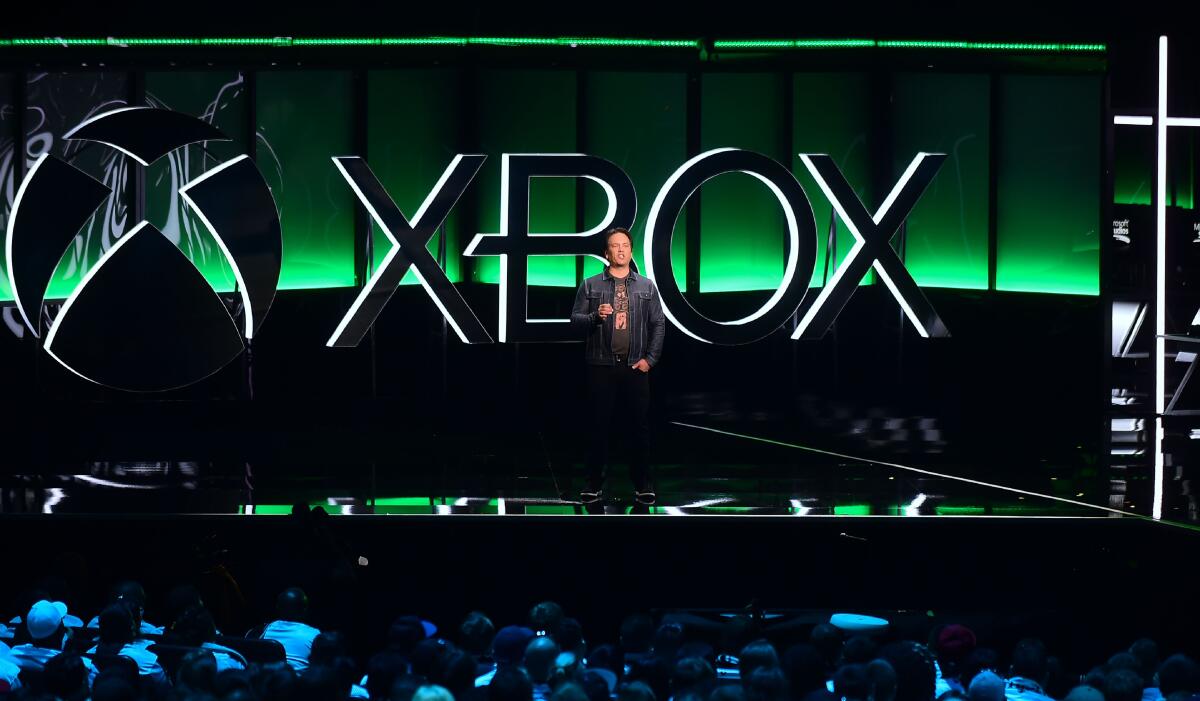 Phil Spencer stands in front of the Xbox logo onstage.