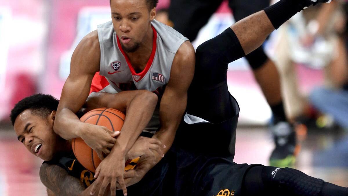 Justin Bibbins, getting tied up by Arizona guard Parker Jackson-Cartwright (top) during a game last season, is part of a formidable backcourt for Long Beach State.
