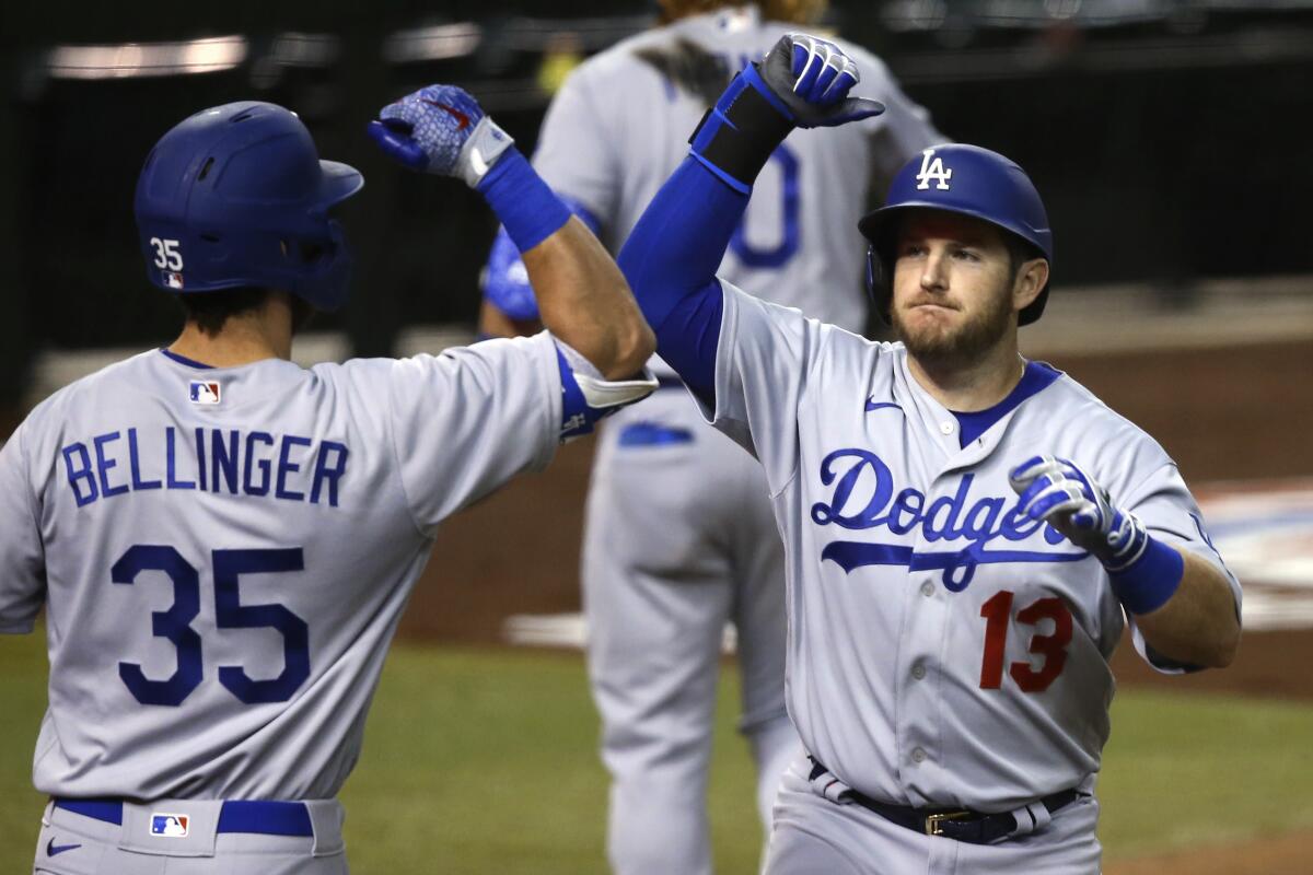 Dodgers first baseman Max Muncy, right, is congratulated by teammate Cody Bellinger.