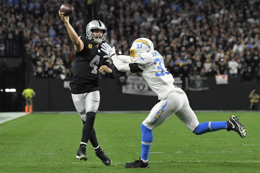 Las Vegas Raiders quarterback Derek Carr (4) attempts to pass over Los Angeles Chargers free safety Derwin James Jr. (33) during the first half of an NFL football game, Sunday, Jan. 9, 2022, in Las Vegas. (AP Photo/David Becker)