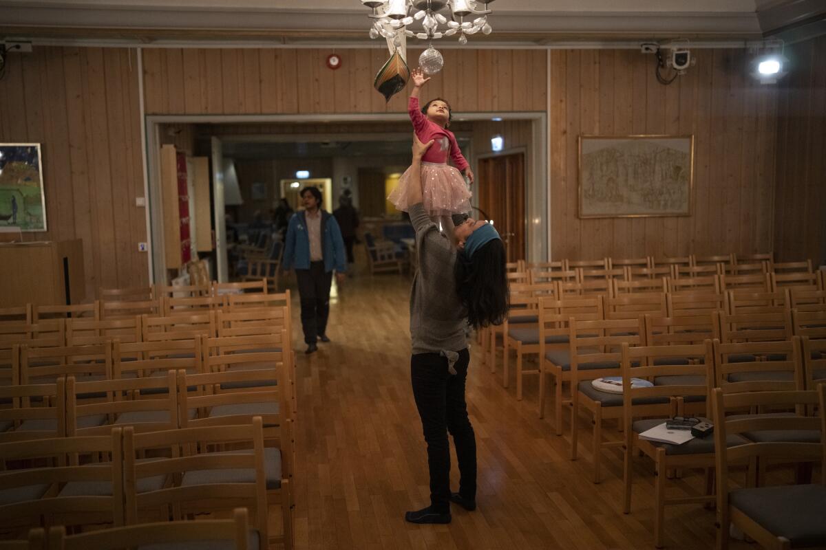 A woman holds her daughter up in the air after a service at Svalbard Kirke.