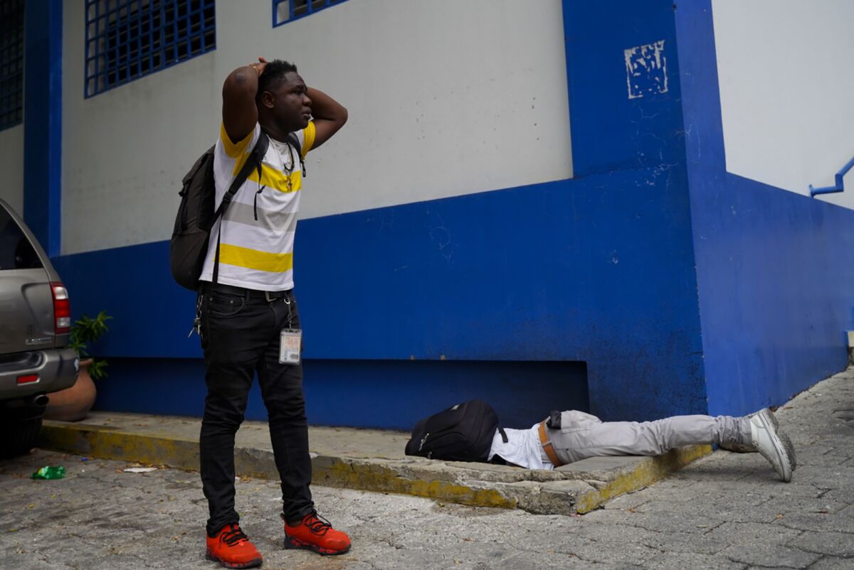 Haitian journalist Romelo Vilsaint, who was fatally wounded lies face down inside the parking lot of a police station, in Port-au-Prince, Haiti, Sunday, Oct. 30, 2022. Vilsaint died Sunday after being shot in the head when police opened fire on reporters demanding the release of one of their colleagues who was detained while covering a protest, witnesses told The Associated Press. (AP Photo)