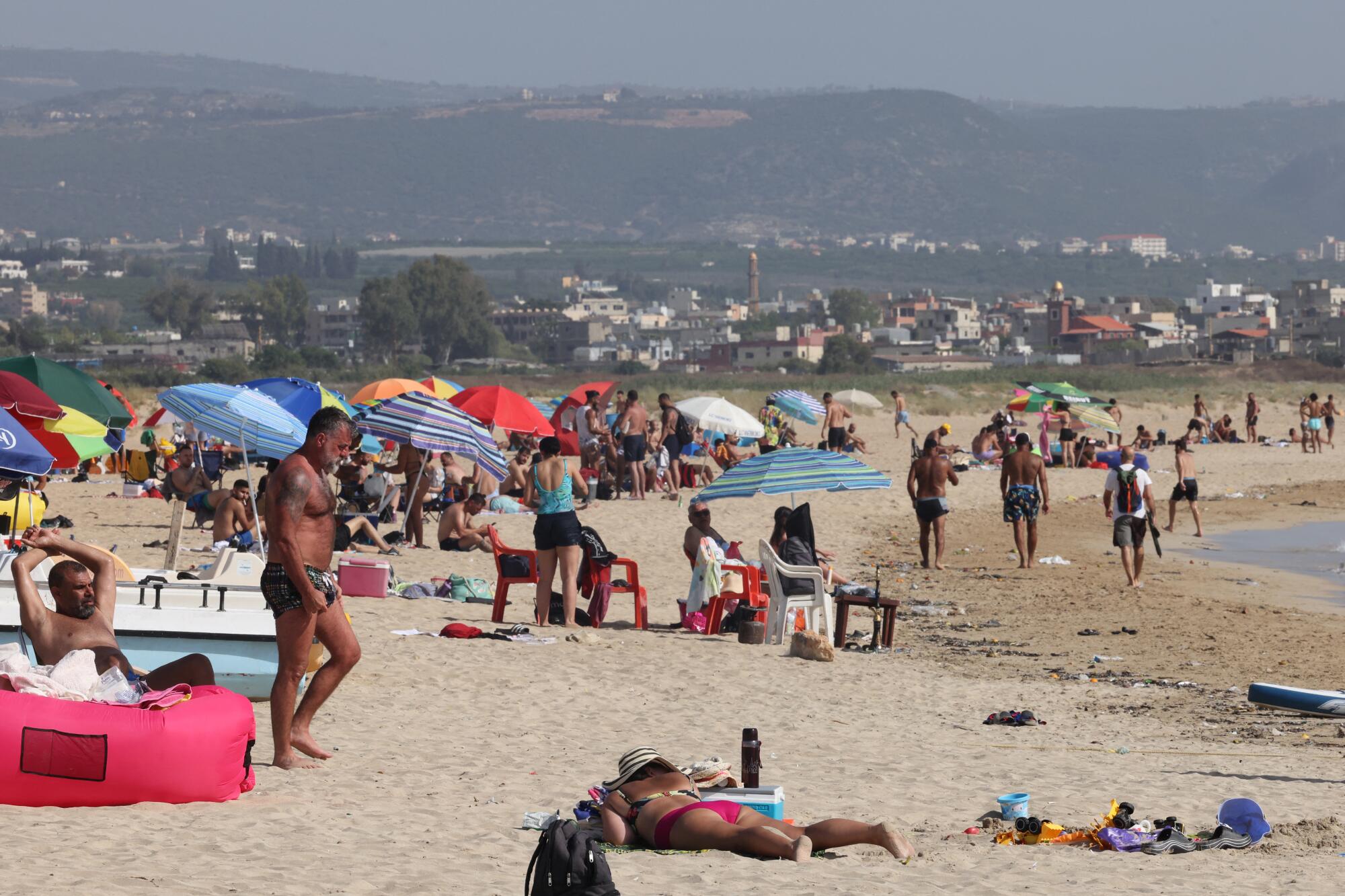 人们在黎巴嫩港口城市提尔的海滩上消磨时光。