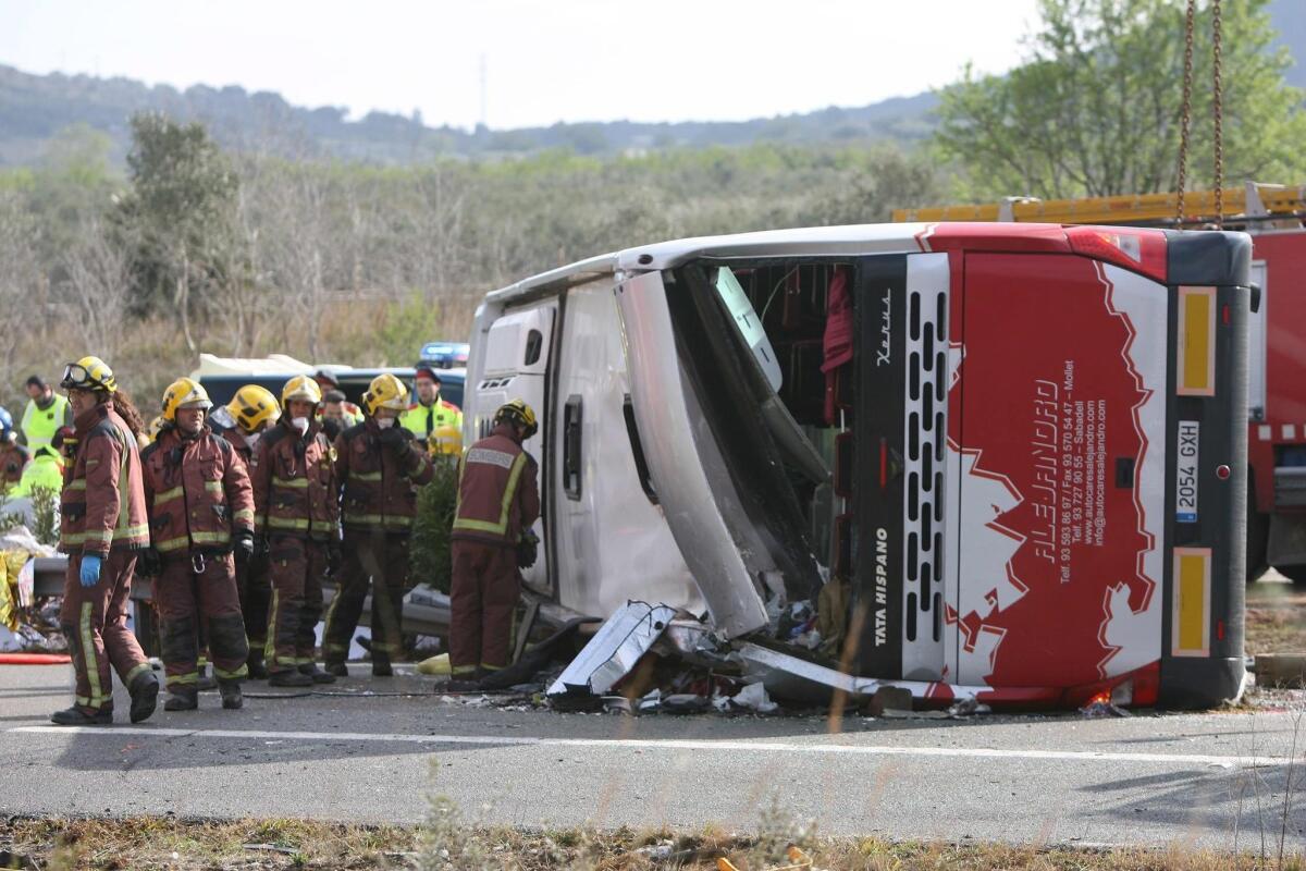 Firefighters work at the site of a bus crash in Freginals, northeastern Spain.