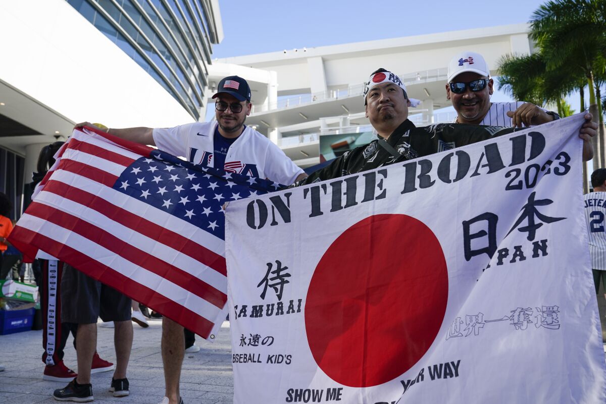 Shinjiro Suzuki sostiene una bandera de Japón previo a la final del Clásico Mundial de béisbol