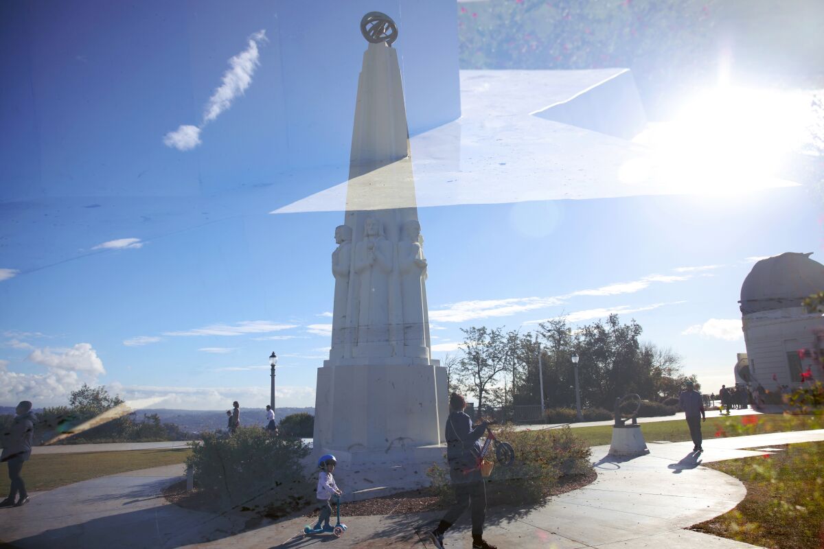 The Astronomers Monument at Griffith Observatory and the edge of the monument is seen in a double exposure.