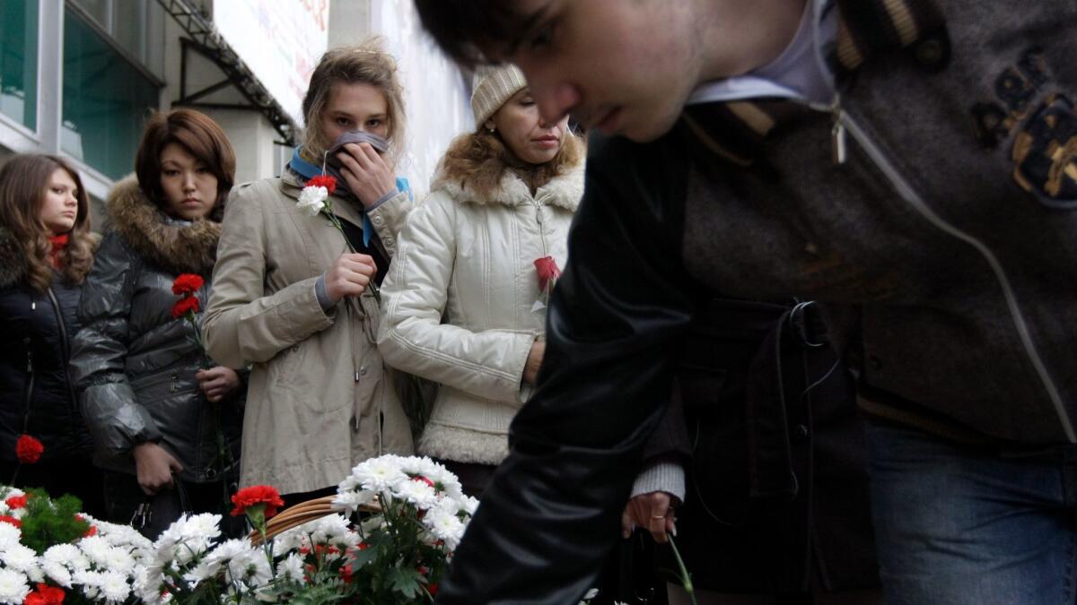 People lay flowers outside the Moscow theater that Chechen gunmen seized in 2002. Relatives of the slain hostages mark the tragedy's seventh anniversary Oct. 26, 2009.