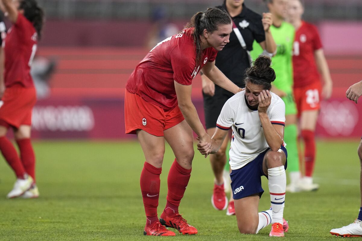 Canada's Vanessa Gilles, left, comforts United States' Carli Lloyd after a women's semifinal soccer match