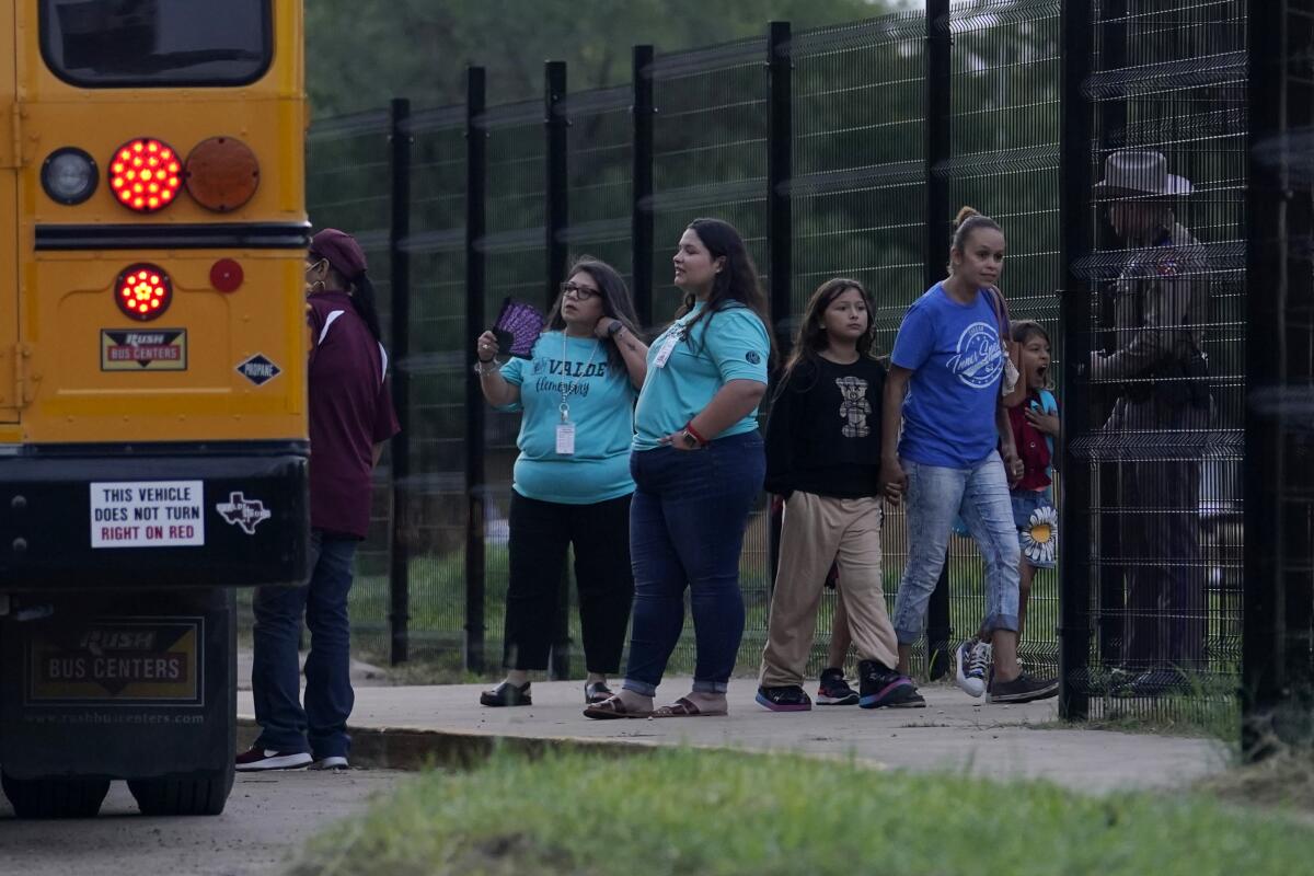 Students arrive at Uvalde Elementary for the first day of school as workers continue construction on a new fence, Tuesday, Sept. 6, 2022, in Uvalde. Students are returning to campuses for the first time since the shootings at Robb Elementary where two teachers and 19 students were killed. (AP Photo/Eric Gay)