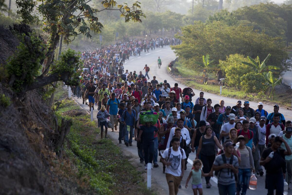 Migrantes centroamericanos que forman parte de una caravana rumbo a la frontera entre México y Estados Unidos, camina por la carretera en Escuintla, Chiapas, México.