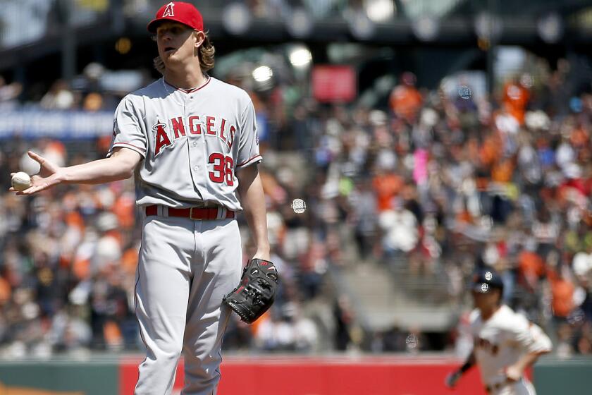Angels starting pitcher Jered Weaver gave up a leadoff home run to Giants left fielder Nori Aoki (background). He then gave up a home run to Joe Panik in the next at-bat.