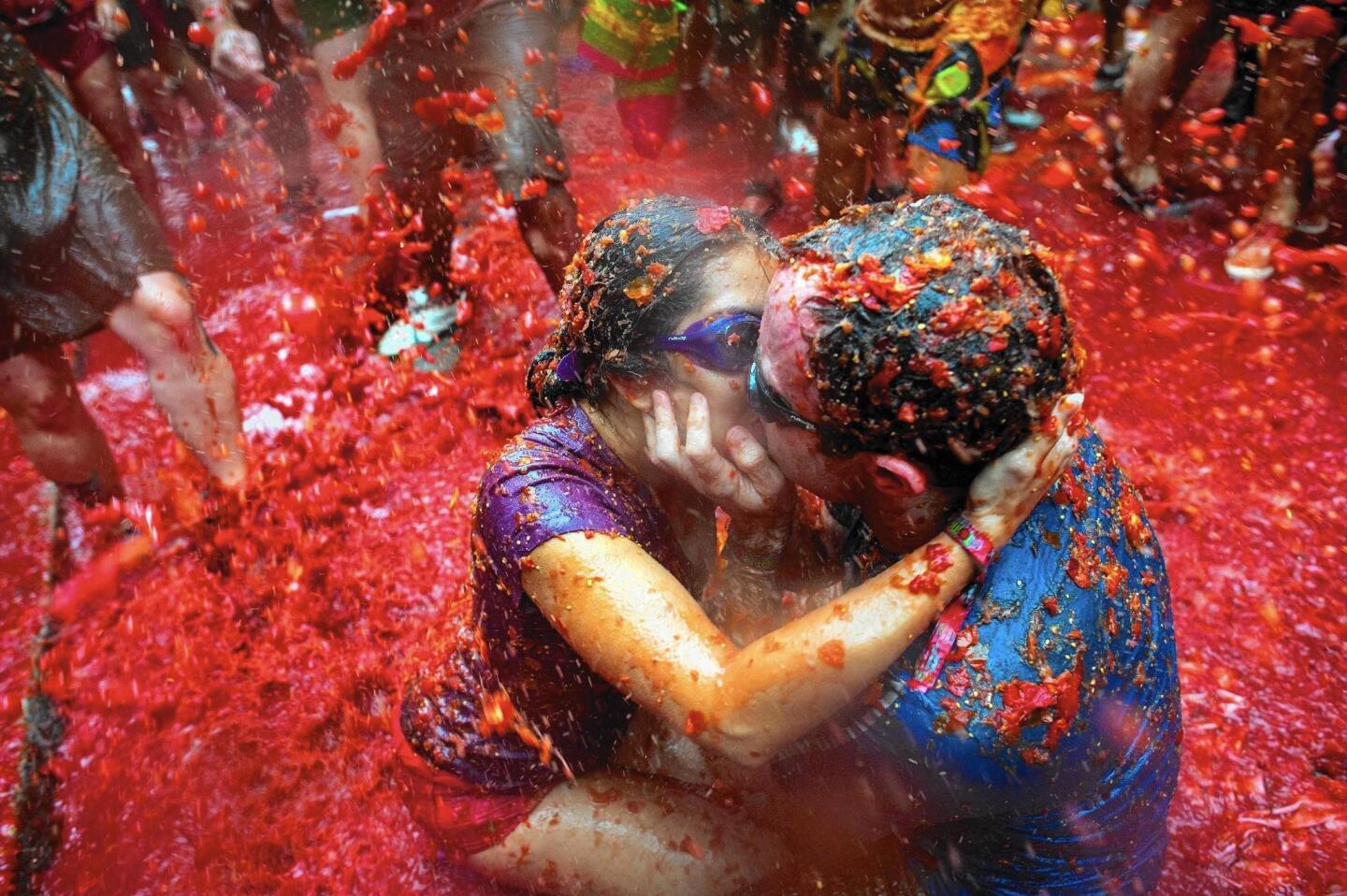 Two revelers kiss while covered in tomato pulp during the annual Tomatina festival in Bunol, Spain, where the world’s biggest tomato fight is held annually.