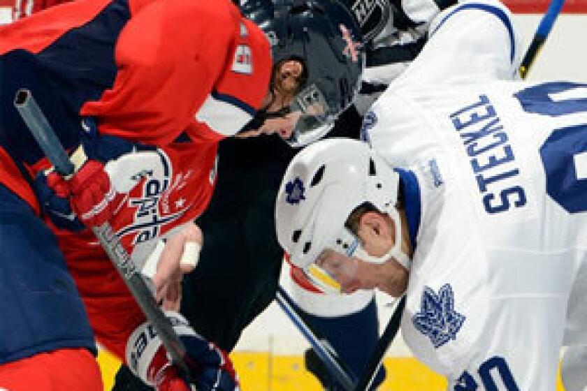 Nicklas Backstrom of the Washington Capitals takes a face-off against David Steckel of the Toronto Maple Leafs.