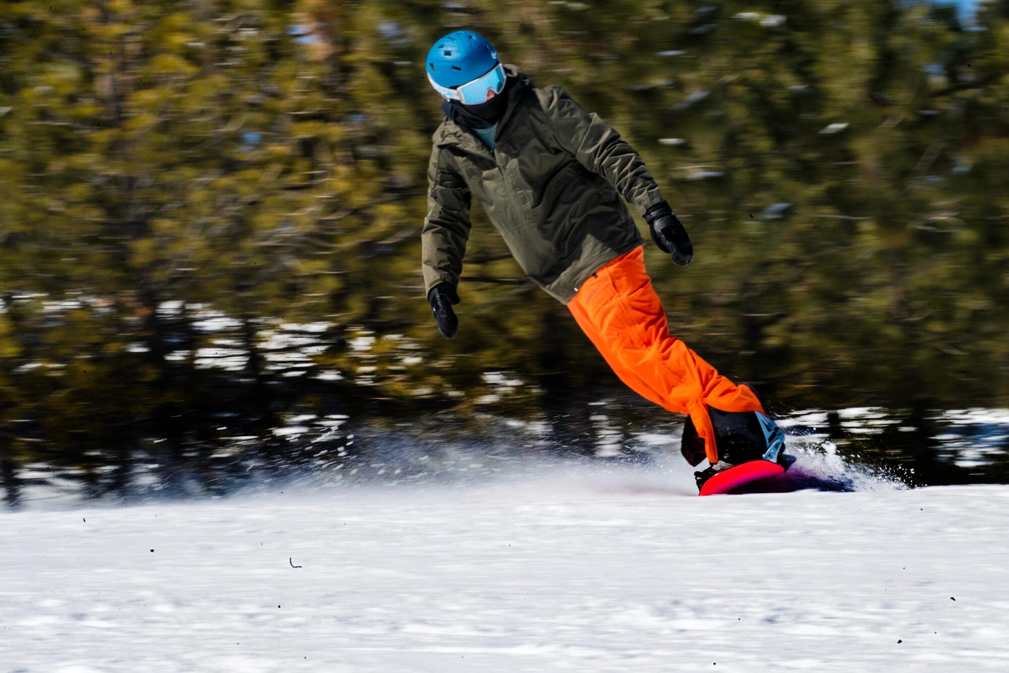 A snowboarder glides down the slopes on a sunny morning at Big Bear Mountain Resort.