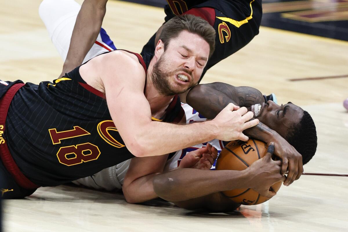 Cleveland Cavaliers' Matt Dellavedova, left, ties up Philadelphia 76ers' Shake Milton for a jump ball during the second half of an NBA basketball game Thursday, April 1, 2021, in Cleveland. (AP Photo/Ron Schwane)