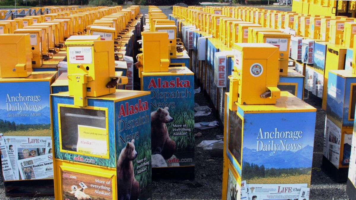 Hundreds of old newspaper sales boxes are shown Monday in a vacant lot near the former offices of the Alaska Dispatch News in Anchorage.