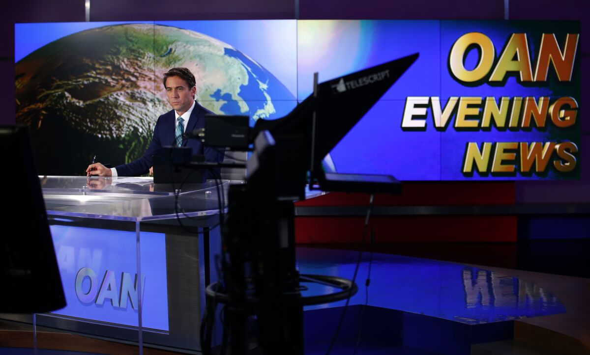 Patrick Hussion waits during a break while hosting an evening news segment on One America News Network.