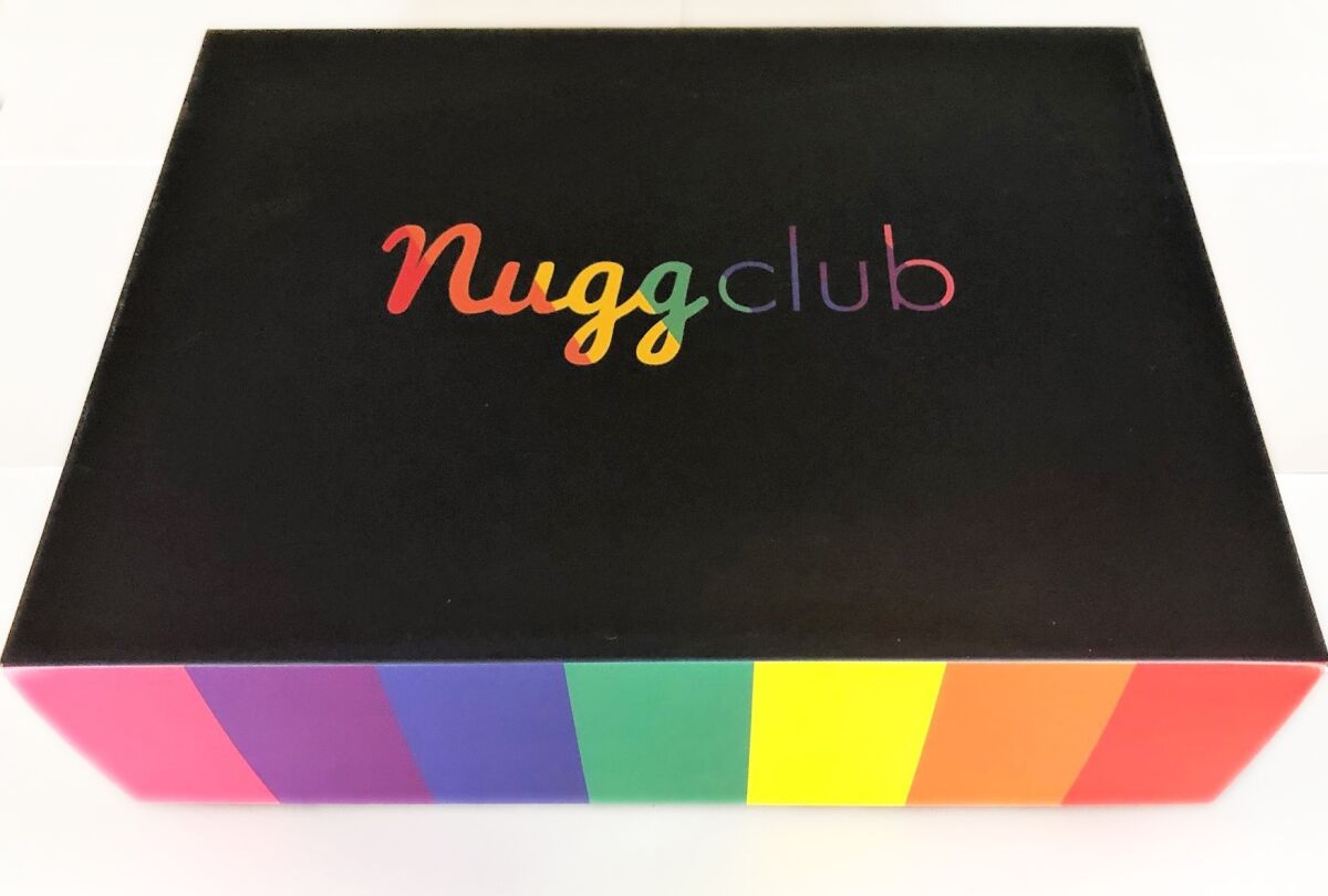 A rainbow-striped box with Nugg Club printed on the lid.