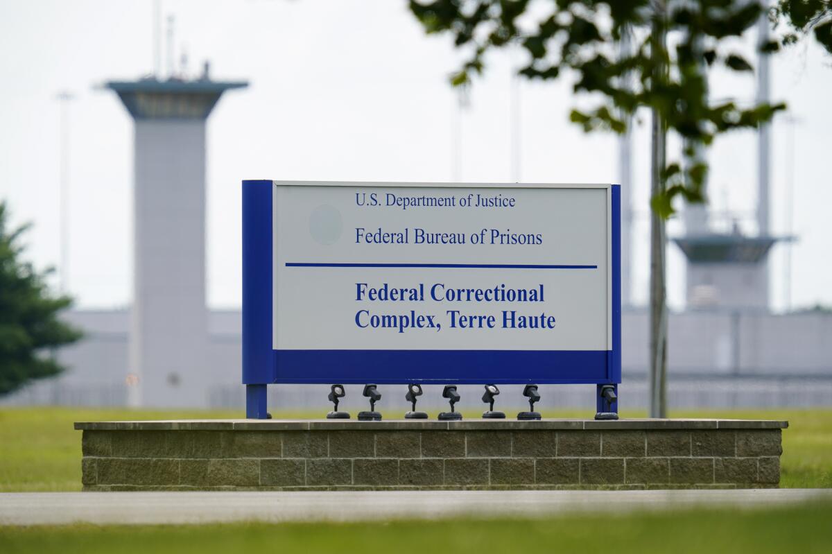 A sign reads U.S. Department of Justice, Federal Bureau of Prisons, Federal Correctional Complex, Terre Haute
