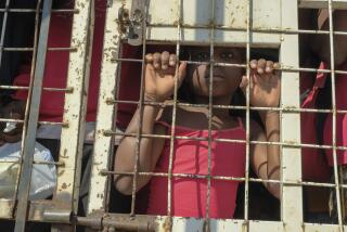 A child stands amid people who were detained for deportation to Haiti inside a police truck on a border bridge that connects Dajabon, Dominican Republic with Haiti, Monday, March 18, 2024. (AP Photo/Ricardo Hernandez)
