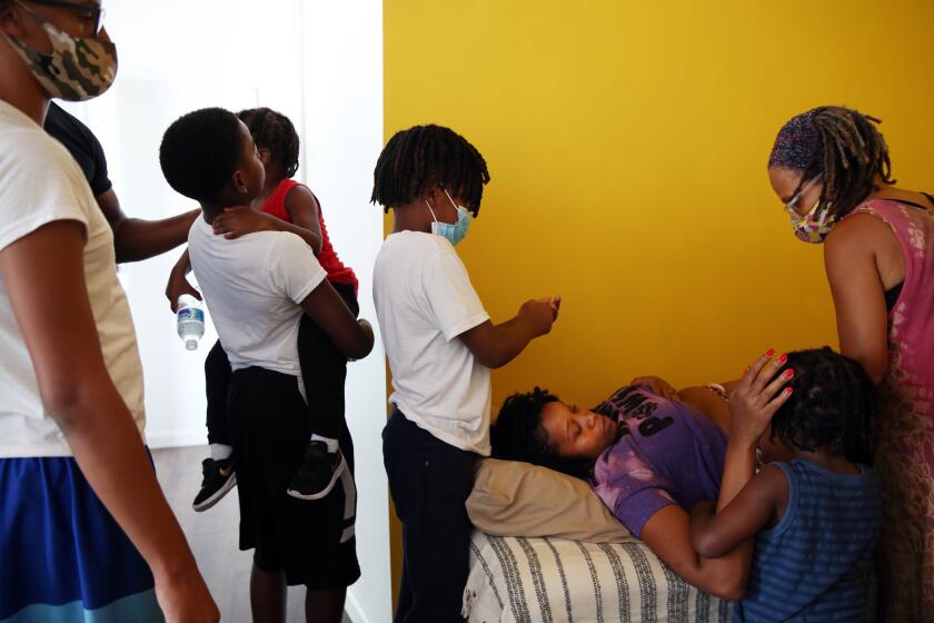 LOS ANGELES, CA - SEPTEMBER 30: Tamara Robertson is examined by midwife Kimberly Durdin during her 26-week check-up at Kindred Space LA on Wednesday, Sept. 30, 2020 in Los Angeles, CA. Tamara's four boys, partner and younger brother are with her, invited to ask questions and participate, during the hour-long visit. In turn, Kimberly gives the kids tips on how they can help and what they can expect from a pregnant mom. (Dania Maxwell / Los Angeles Times)