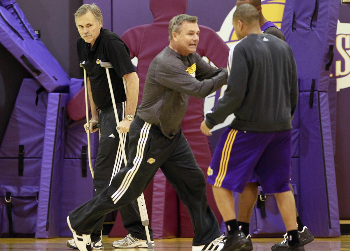 Dan D'Antoni coaches Lakers players during a practice in 2012 while his brother, head coach Mike D'Antoni, watches.
