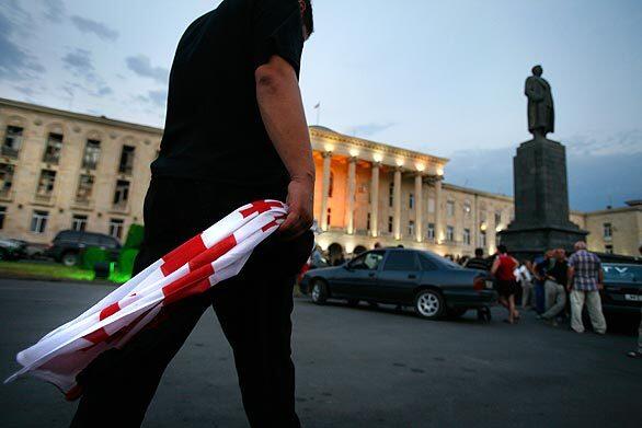 A resident of Gori takes a Georgian flag to Stalin Square in the heart of the central Georgian city, which was cut off from the rest of the country by Russian forces for the last two weeks.