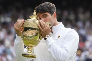 Carlos Alcaraz of Spain kisses his trophy after defeating Novak Djokovic of Serbia in the men's singles final at the Wimbledon tennis championships in London, Sunday, July 14, 2024. (AP Photo/Kirsty Wigglesworth)