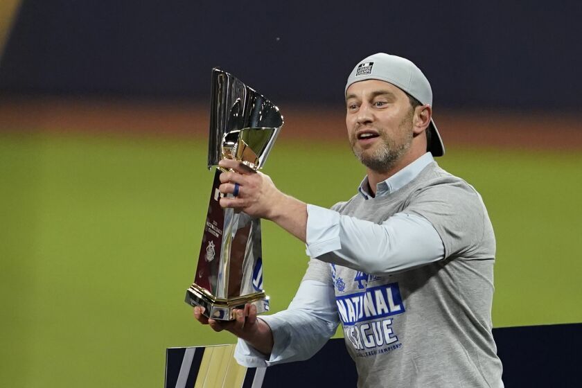 Los Angeles Dodgers President of Baseball Operations Andrew Friedman celebrate with the trophy after winning Game 7 of a baseball National League Championship Series against the Atlanta Braves Sunday, Oct. 18, 2020, in Arlington, Texas. (AP Photo/Tony Gutierrez)