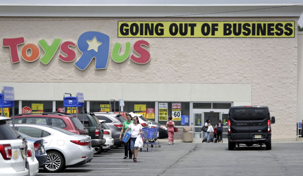 Bargain hunters return to their cars after shopping at a Toys R Us store in Totowa, N.J., on June 1.