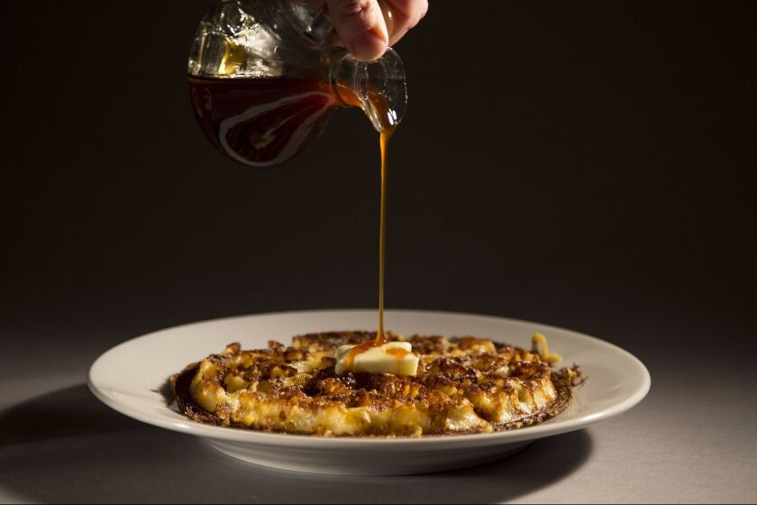 LOS ANGELES, CA - JULY 13, 2017: Apple cider syrup is poured onto a cornmeal waffle made in the Los Angeles Times test kitchen from a recipe out of the cookbook from the restaurant Brown Sugar Kitchen in West Oakland on July 13, 2107 in Los Angeles, California.(Gina Ferazzi / Los Angeles Times)